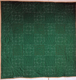 The forest green back highlights the many free motion point-to-point quilting designs