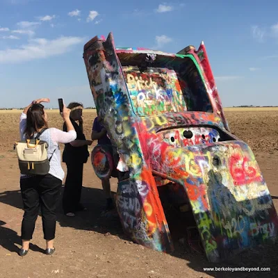 visitor taking a picture at Cadillac Ranch in Amarillo, Texas