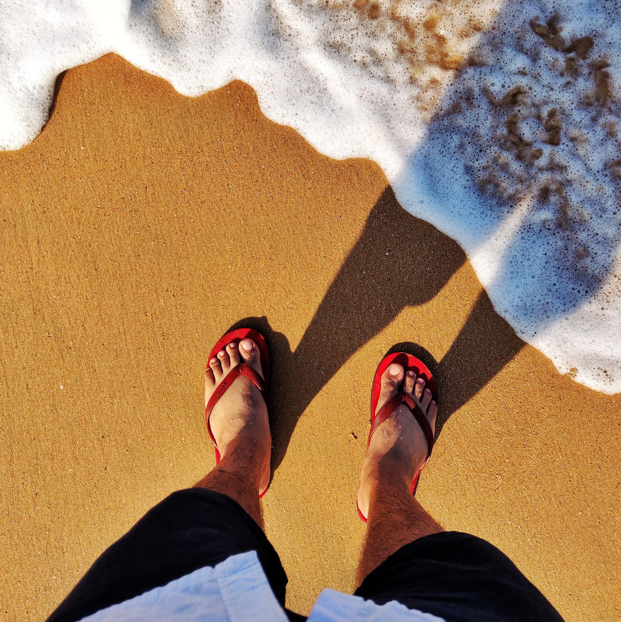 Water hitting my feet at the shore outside hotel