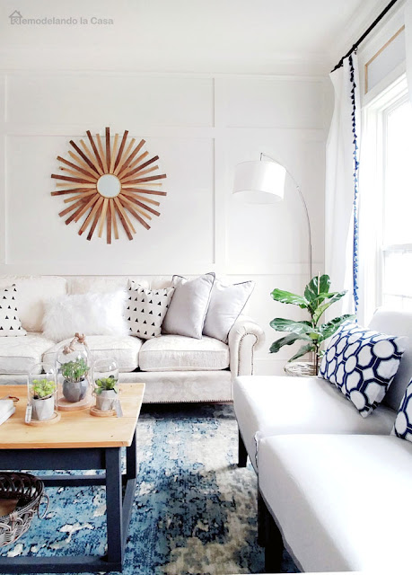 white and blue living room with board and batten and sunburst mirror