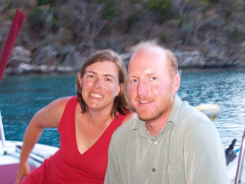 A photo of Janet and Damon on a boat in the Caribbean.  They are smiling and are a bit sun burnt.