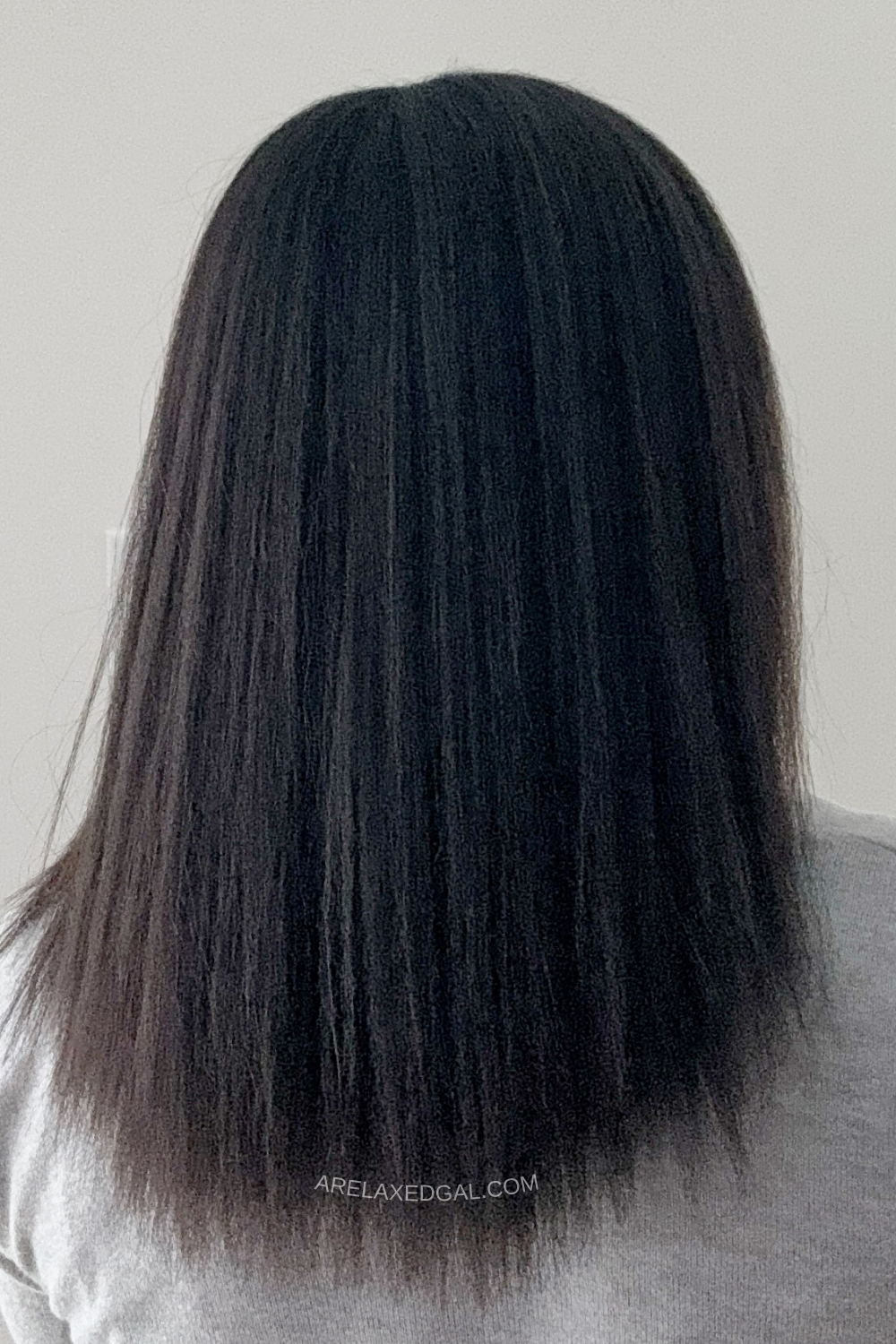 woman showing back of hair after getting relaxer touch-up