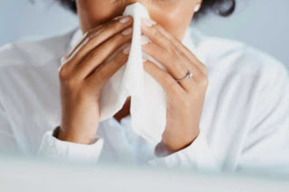 Lady holding a tissue to her nose