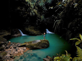 Turista maravillado de pie en una piedra en la piscina natural del Gran Cañón de Ñachiyaku, disfrutando de las impresionantes cascadas del entorno natural