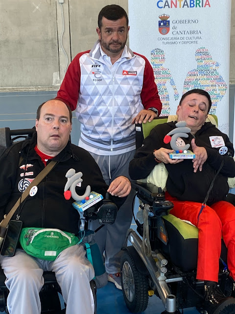 El entrenador y dos jugadores de boccia con unos trofeos