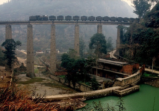 Train passes through and old bridge in Weiyuan, China 