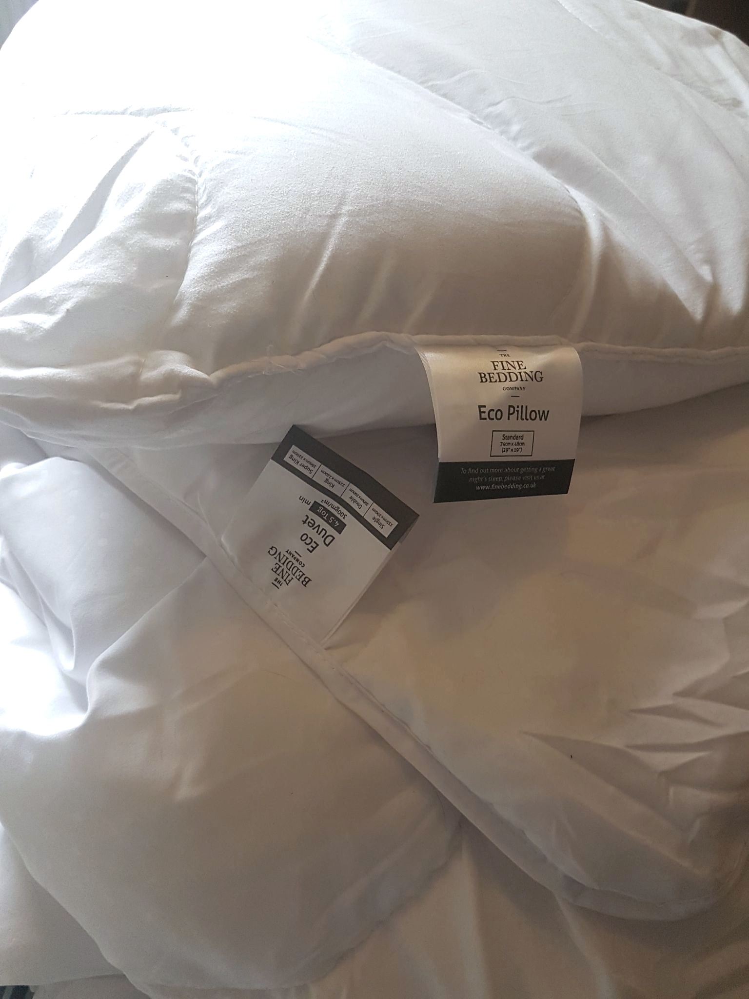 The Fine Bedding Company white Eco Duvet and Pillow made from recycled plastic sitting on top of one another