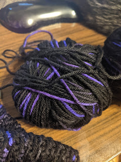 Ball of black yarn with purple accents