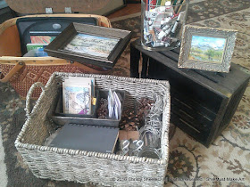 Gathering beautiful items for display table.  Baskets and crates with pine cones and strings of lights. 