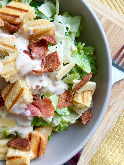 Overhead shot of grilled cheese Caesar salad with Marzetti dressing in a grew bowl.