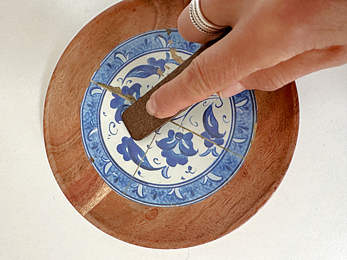 rubbing round design on round wooden dish