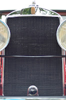 front view of a vintage vehicle with grill and headlights