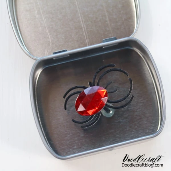 Make the perfect trick for Halloween with this little surprise spider mint tin! This cute little tin is the equivalent of telling someone there's a spider in their hair! I made this and stuck it on my refrigerator and guess what!? It tricked all three of my teenagers!