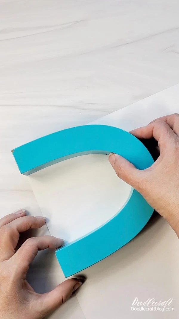 Turn the adhesive vinyl over and place the rainbow piece on top of the vinyl.