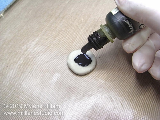 Dripping the colourant onto a flattened disk of epoxy clay