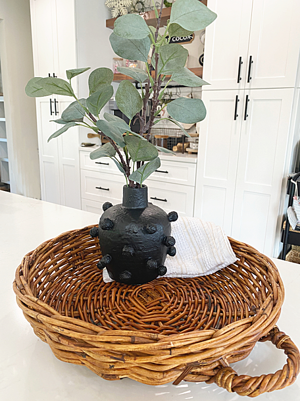 textured vase with greens and wicker basket