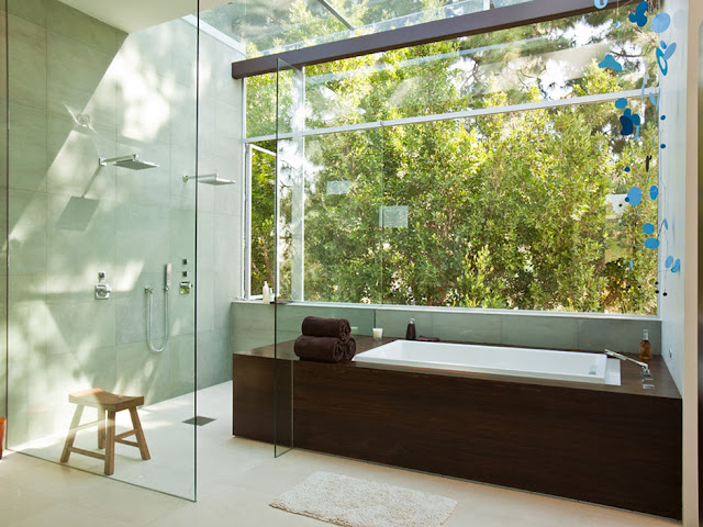 Picture of dark brown hot tub by the window next to the shower cabin in the bathroom