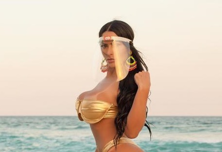 Miss Bumbum Ellen Santana posa de biquini dourado e equipamento de proteção em praia carioca