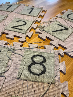 gray knitted milestone blocks number pieces pinned to blocking mats