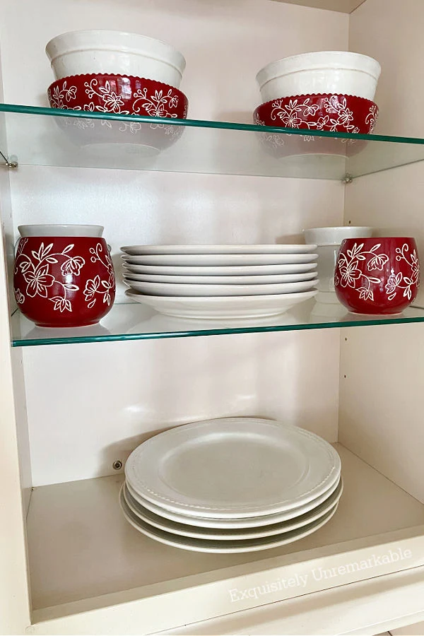 Floral Lace Cranberry Dishes in a cabinet