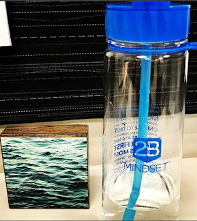 Water bottle next to a picture of water in a lake