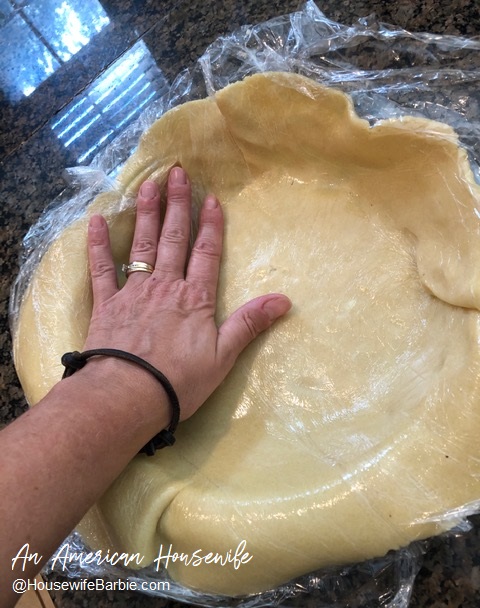 pressing a fragile pie crust into a pie plate