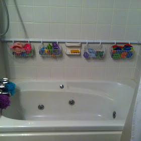 Image: 2nd shower rod against the back wall with wire baskets on curtain hooks to organize bath toys