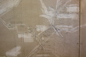 a drawing of a map on a worn wall, with names like Styx River written on the map that depicts a sewer system in central Helsinki.