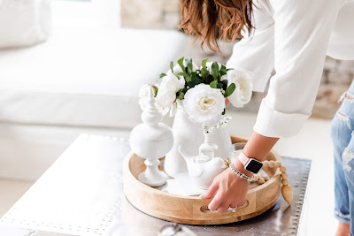 Styled wood tray with white decor on coffee table 