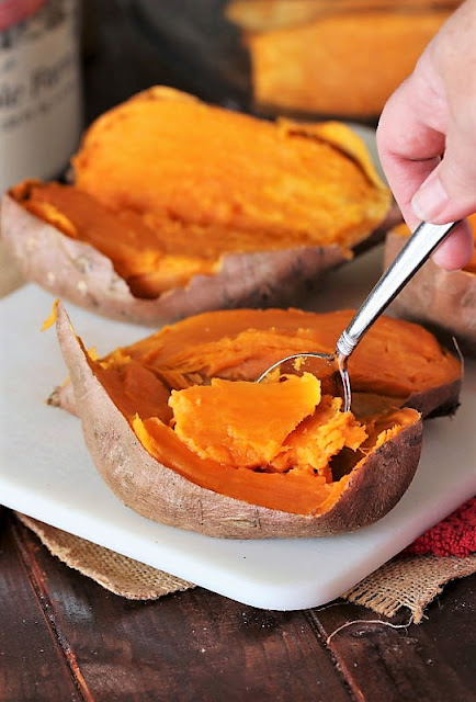 Scooping Pulp Out of Cooked Sweet Potatoes Image