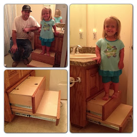 Child standing on top of two sliding drawer stairs built bathroom sink cabinet.