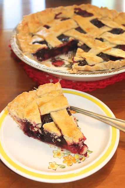 Mixed berry pie with a slice cut out.