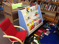 picture of the bookshelf and chairs in the read to me center