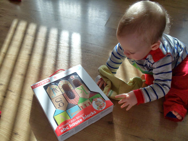 little boy sat on the floor reaching out for wooden blocks