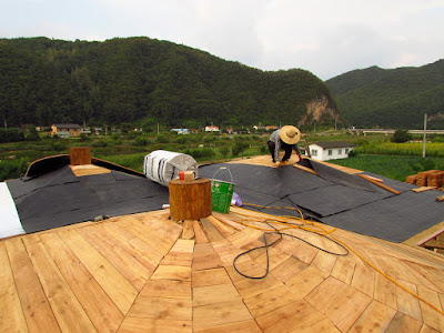 Mise en place de la couche de revêtement étanche 방수 시트 sur la toiture.