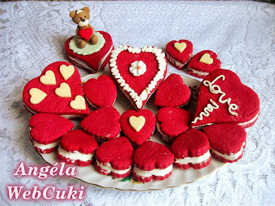 Valentin napi kicsi és nagy szív alakú, piros kekszek, tejszínes fehér csokoládés krémmel töltve.