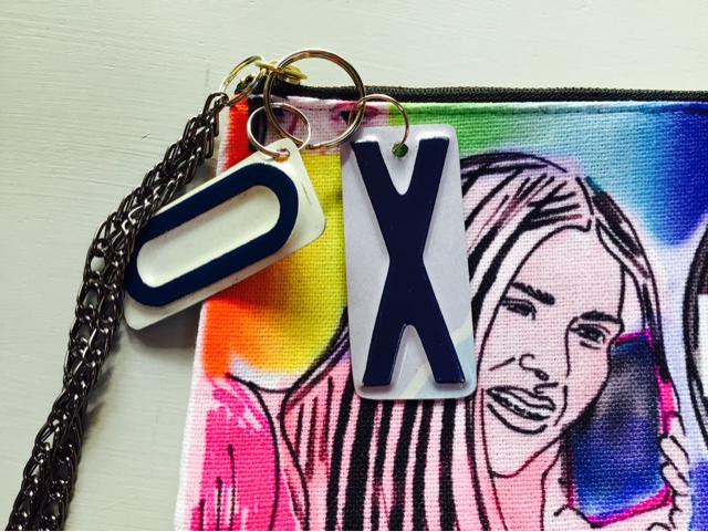 colorful detail of a clutch with an op art illustration of a girl holding a cell phone and talking into the phone