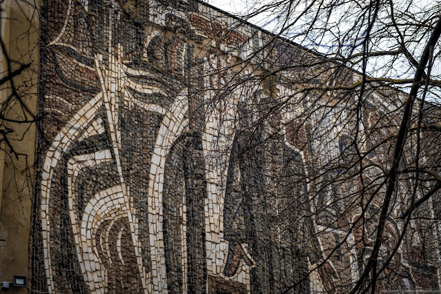 Ветка дерева закрывает мозаику на здании