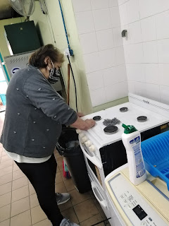 La alumna Rosario compartiendo su experiencia limpiando el artefacto cocina.