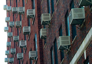 Window air conditioning units in East Harlem, New York. (Credit: Jason Kuffer / Wikimedia Commons) Click to Enlarge.