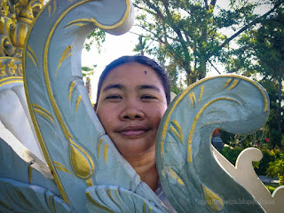 Woman Traveler Face Among Carving Arches Of White Carved Seat Building In The Tropical Garden On A Sunny Day