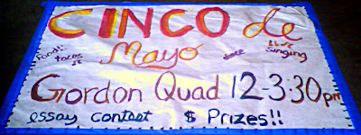 Cinco de Mayo red writing on white paper surrounded by blue tape.