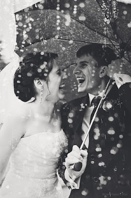 Wedding couple laughing in the rain