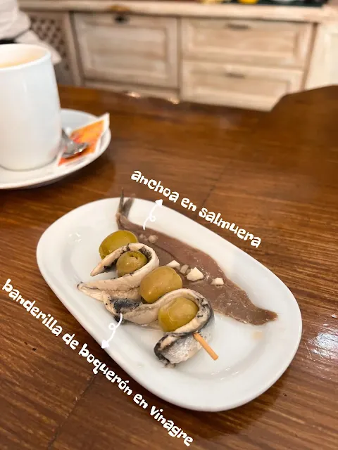 餐桌上的醃漬鯷魚anchoa en salmuera和醋醃的小鯷魚banderilla de boquerón en vinagre串上橄欖