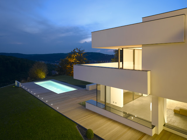 Photo of an amazing home and its pool area at sunset as seen from the balcony