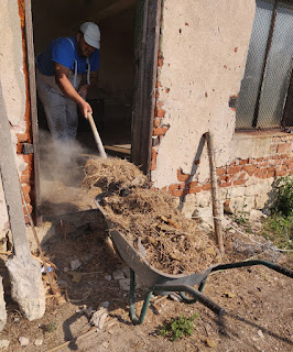 Halil shovelling out the old hay and dust