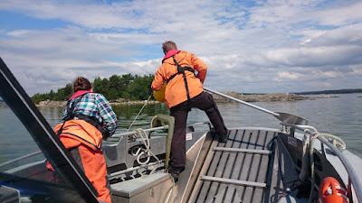 Kaksi työntekijää veneen keulassa.