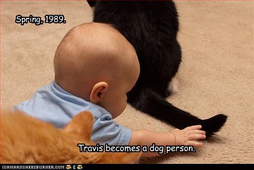 photo of a baby about to grab a cat's tail