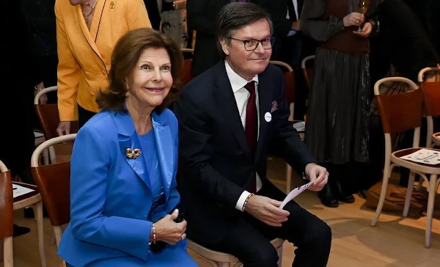 Queen Silvia wore a royal navy tuxedo lapel blazer jacket and navy midi skirt by Georg et Arend. Mourjjan suit. Gold brooch