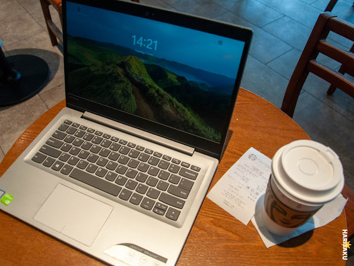 Laptop dan segelas kopi di atas meja di Starbucks